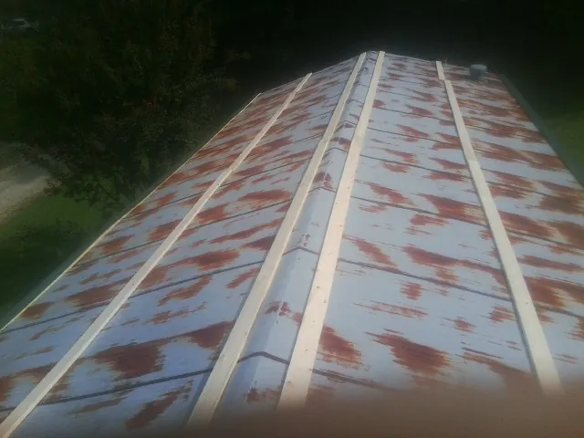 Rusted metal roof panels with new wood purlins before replacement — Storm Damage Roof Repair in Wilsons Mills by Roofing Brothers